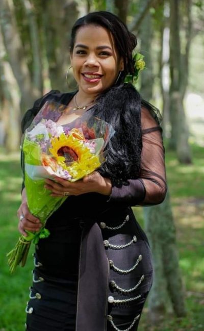 La voz principal de Mariachi Estrella Mexicana con un ramo de girasoles