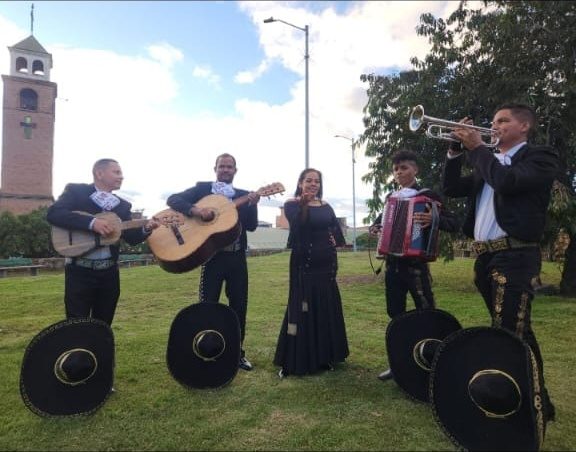 El grupo tocando al aire libre en Bogotá con los sombreros charros en el suelo