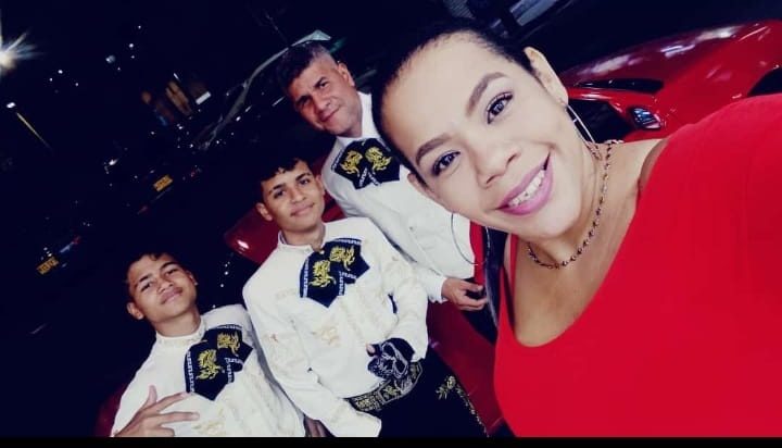 Integrantes del mariachi con traje blanco durante una serenata nocturna